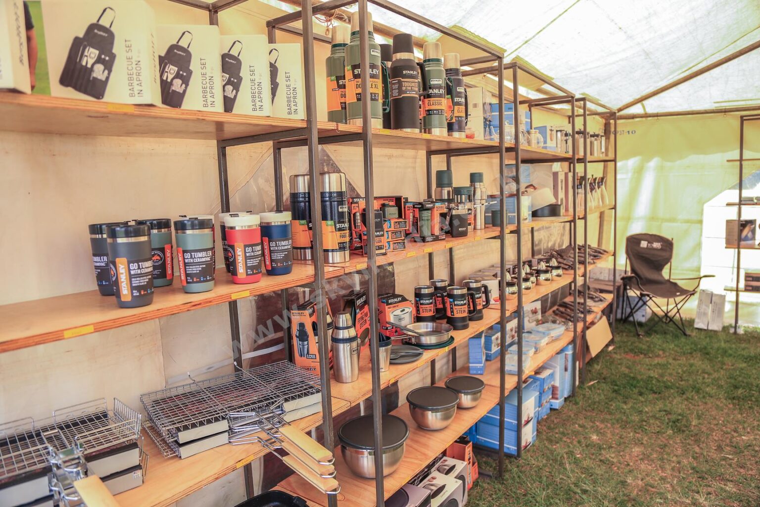 Shelves displaying Stanley outdoor gear, including thermoses, mugs, and BBQ sets
